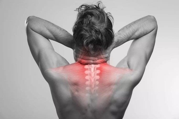 Cervical spine highlighted on a person holding the back of their neck